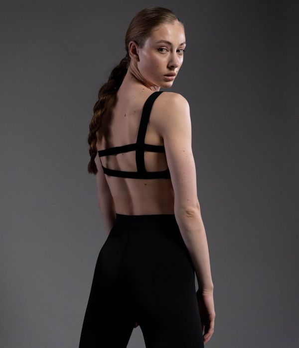 Person in a strong yoga warrior pose against a dark background.